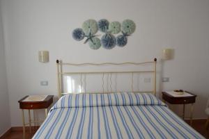 a bedroom with a bed with a blue and white comforter at Casa Signorile in Villasimius