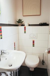 a bathroom with a white toilet and a sink at Black Forest Living am Marktplatz in Freudenstadt +10 photos