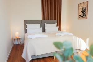 a bedroom with a bed with two towels on it at Black Forest Living am Marktplatz in Freudenstadt