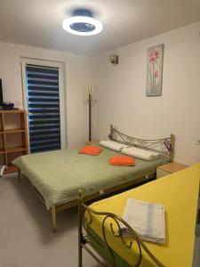 a room with two beds and a table and a window at Irma Haus in Jadranovo