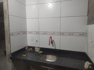 a bathroom with a sink and white tiled walls at Casa branca in Aracaju +5 photos