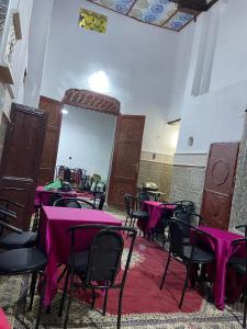 a room with tables and chairs with pink table cloth at Ryad Cherkaoui in Fez +7 photos