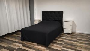 a bedroom with a black bed and a dresser at Rental Tigre in Tigre +40 photos