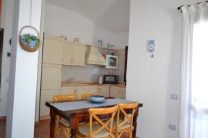 a kitchen with a table and some chairs and a table and a kitchen at Casa Signorile in Villasimius