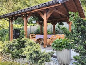a wooden gazebo with a table and chairs at Toffee House in Zator