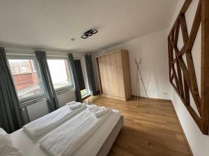 a bedroom with a large white bed and windows at Between in Lübeck