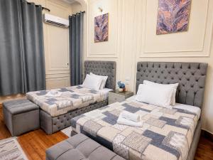 a bedroom with two beds and a chair in it at Yacoubian Suites in Cairo