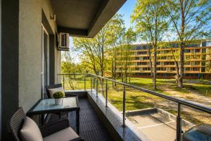 a balcony with chairs and a table and a building at Coralia Luna Park Apartments in Mamaia