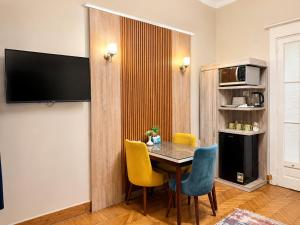 a dining room with a table and yellow chairs at Yacoubian Suites in Cairo