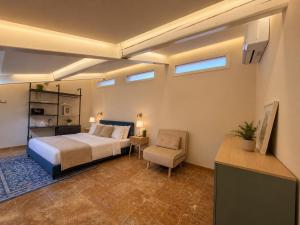 a bedroom with a bed and a chair at Galeo Suites in Florence