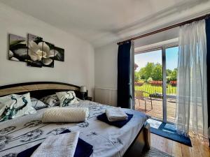 a bedroom with a bed and a large window at Orlikowe Wzgórze in Rabe +42 photos