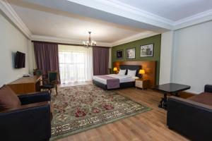 a bedroom with a bed and a living room at Cathedral Plaza Hotel in Gyumri