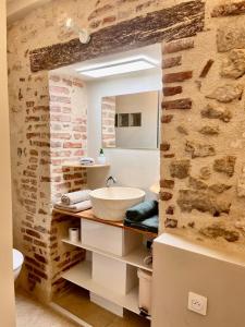 a bathroom with a sink and a brick wall at Cozy loft, Loire et chateaux in Messas