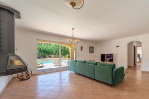 a living room with a green couch and a fireplace at La Bastide au Soleil in Flayosc