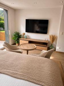 a living room with a tv and a table and chairs at Le Cocon, Jacuzzi privé Spa Francorchamps in Spa