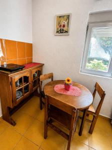 a kitchen with a table and a small table and chairs at Dodo Obala Apartmani in Sutomore