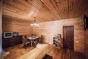 a room with a wooden wall with a table and a couch at Всім бобра in Pulʼmo