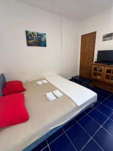 a bedroom with a large bed with two towels on it at Dodo Obala Apartmani in Sutomore