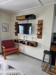 a living room with a television on a wall at Tony's Place in Christ Church