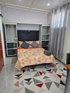 a bedroom with a large bed and a rug at Tony's Place in Christ Church