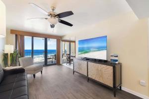 a living room with a flat screen tv and a couch at Beachfront Paradise at Phoenix II 2046 in Orange Beach