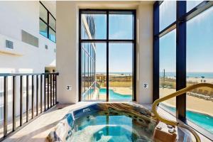 a hot tub in a balcony with a view of the ocean at Beachfront Paradise at Phoenix II 2046 in Orange Beach
