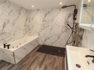 a bathroom with a tub and a sink at Sugar Loft in Wigton +17 photos