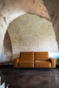a couch in a room with a brick wall at Villa Del Lauro in Ragusa +87 photos