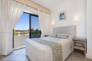 a bedroom with a bed and a large window at Mirra Chana Beachfront Apartments Mooloolaba in Mooloolaba +104 photos