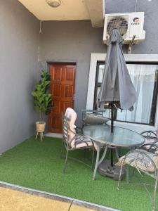 a patio with a table and chairs and a fan at The Well Apartments in Mbabane +3 photos