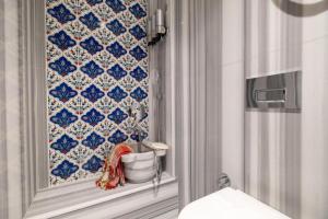 a bathroom with a blue and white tiled wall at Platine Plus Suite in Istanbul