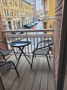 a balcony with two chairs and a table and a street at Magic Downtown Szeged in Szeged
