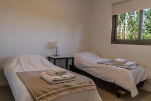 two twin beds in a room with a window at El Castaño Apart in Potrerillos