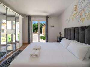 a bedroom with a large white bed with two slippers at La Bastide au Soleil in Flayosc +33 photos