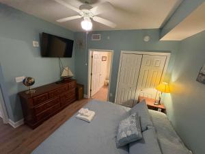 a bedroom with a bed and a flat screen tv at Oceanfront Condo with Shared Pool Hot Tub & Gym in Panama City Beach