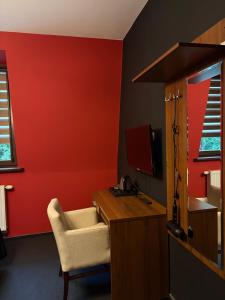 a red room with a desk and a chair at La Melodia in Kościerzyna +57 photos