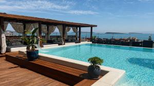 a swimming pool with two potted plants on a deck at Ferush Boutique Hotel in Urla