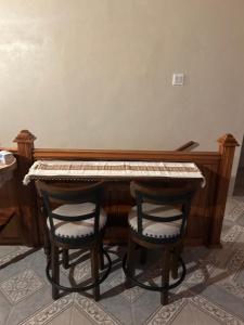 a piano with two chairs in front of it at Pink house in Port Antonio