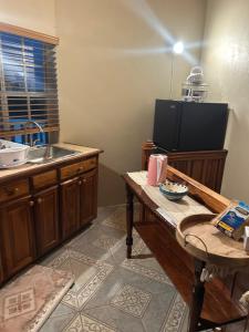 a kitchen with a counter and a sink and a table at Pink house in Port Antonio +6 photos