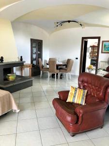 a living room with a leather couch and a table at Villa Mattera - Sea - Hot Springs - Private Parking in Barano d'Ischia