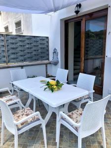 a white table with chairs and a bowl of fruit on it at Villa Mattera - Sea - Hot Springs - Private Parking in Barano d'Ischia