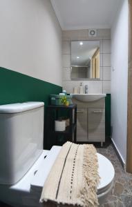 a bathroom with a white toilet and a sink at Olympian Kavala in Kavála +24 photos
