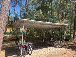 a shelter with two bikes parked under it at Żagiel 3 in Pobierowo