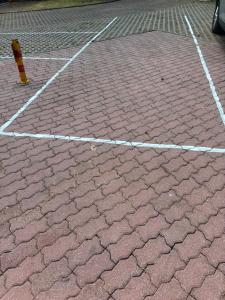 a brick parking lot with a red brick at Żagiel 3 in Pobierowo