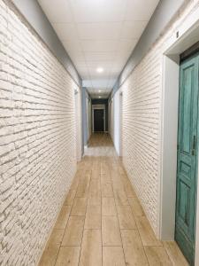 an empty corridor with a brick wall and a door at Hostel Filip 2 in Gdańsk