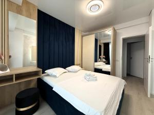 a bedroom with a large bed and a mirror at VIBE Apartments in Năvodari