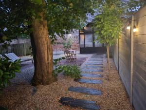 a garden with a tree and a stone walkway at Terra Serena in Frasnes-lez-Anvaing