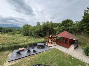 a gazebo with a grill and a table and chairs at Bergblick in Arpaşu de Sus