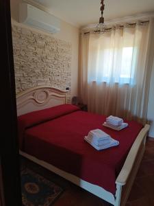 a bedroom with a red bed with towels on it at Villa Valle Tassignana in Casperia