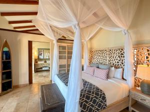 a bedroom with a bed with a canopy at Casa Chameleon Hotel Las Catalinas - Adults Only in Playa Flamingo